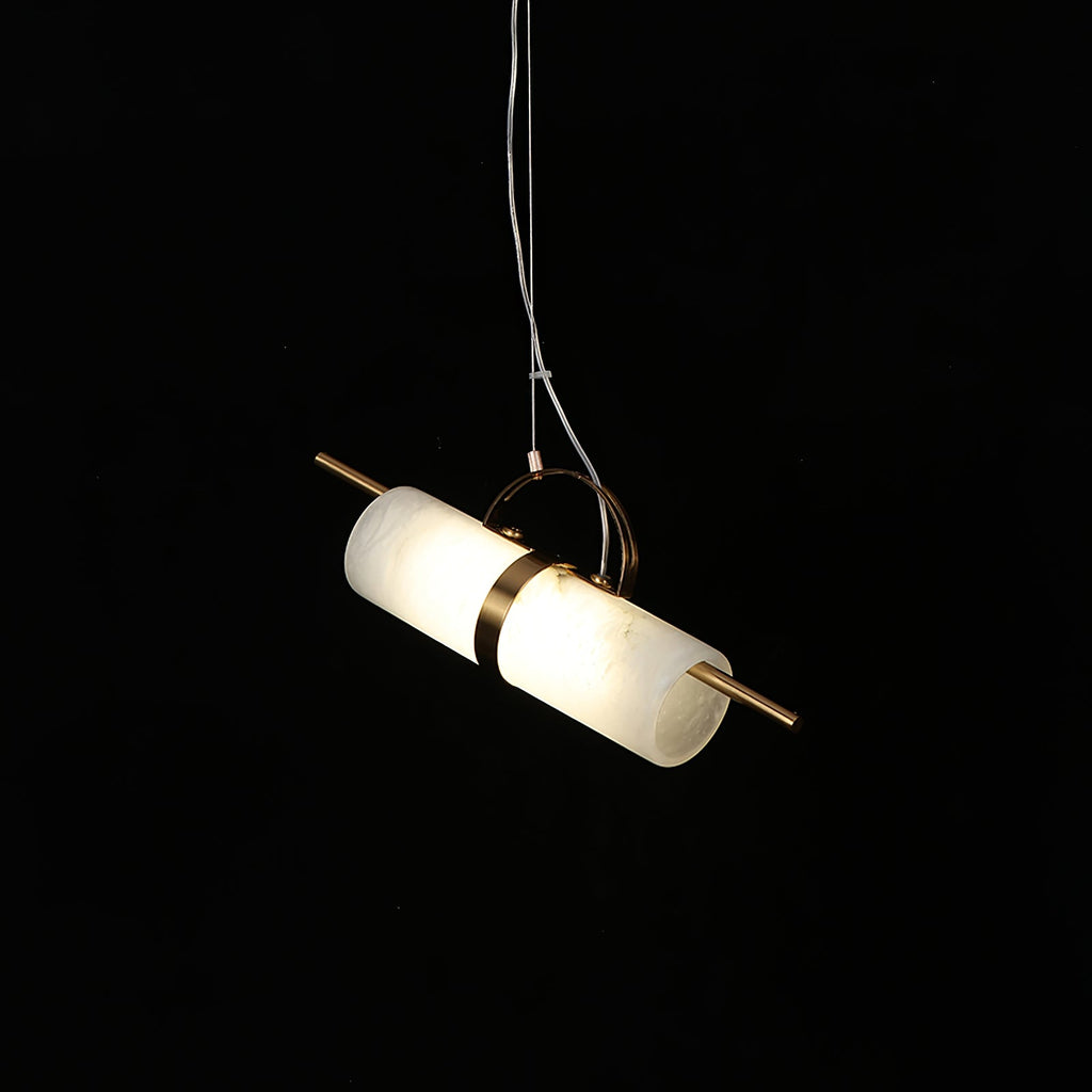 Clérachic Alabaster Cylinder LED Pendant Light angled on its cable against black, the copper band catching light at the tube's centre.