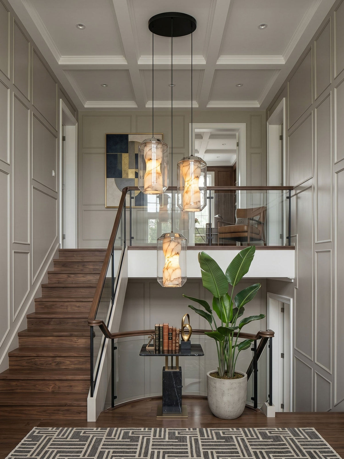 Three Clérachic alabaster pendants at different heights on one round black canopy, hanging in a panelled stairwell beside a wooden staircase.