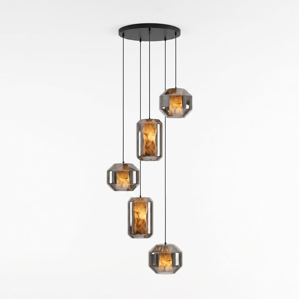 Five smoke grey glass Clérachic pendants, wide and tall, hang at staggered heights from a round black canopy on a white backdrop, each lit amber.