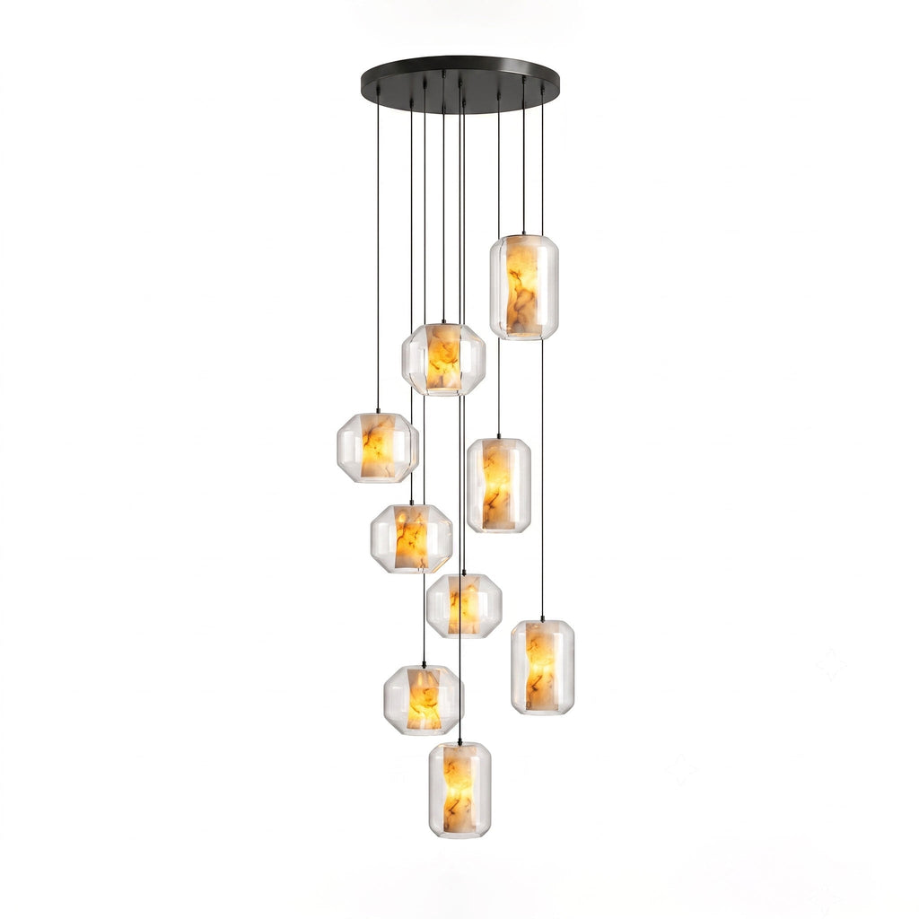A larger cluster of clear glass Clérachic pendants with amber-lit alabaster hangs at staggered heights from a round black canopy on white.