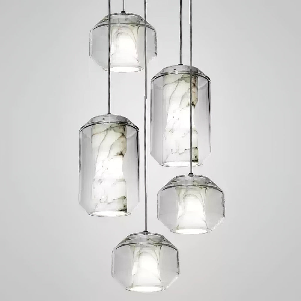 Five Clérachic pendants at staggered heights on a pale grey backdrop, cylinder and rounded-faceted glass shells each holding a veined alabaster core.