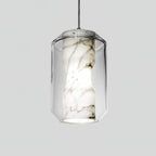 Side view of a tall Clérachic pendant on a pale grey backdrop, showing the waisted alabaster column with dark veining inside clear glass.