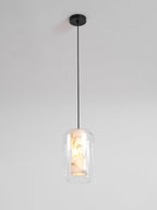 A Clérachic pendant on a single black cord and round black canopy against a pale wall, the alabaster core just visible inside clear glass.