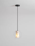 A wide Clérachic pendant on a long black cord with a round black canopy, the alabaster core glowing softly inside clear glass.