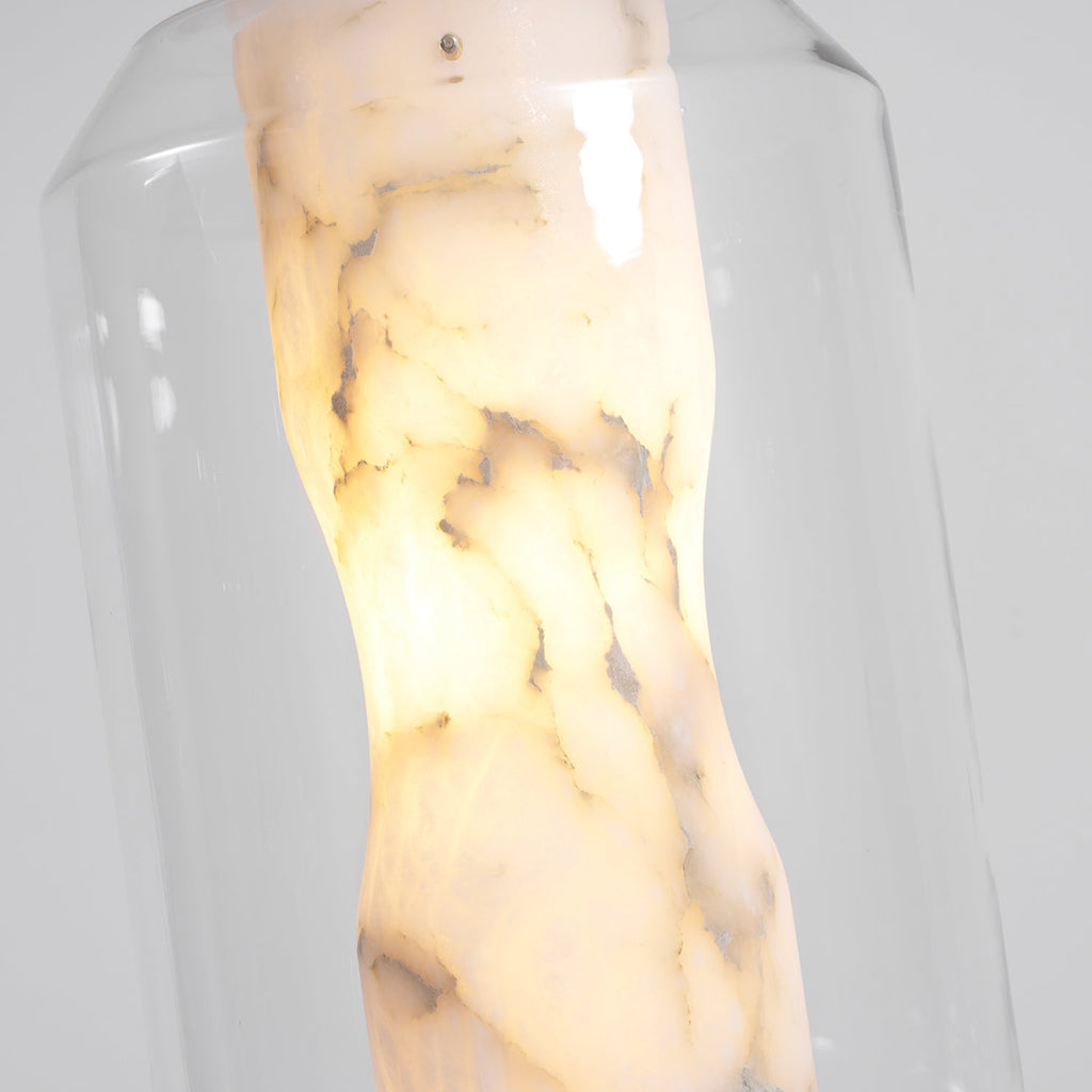 Close view of the alabaster column of this Clérachic pendant lit from inside, showing cream and grey veining behind clear glass.