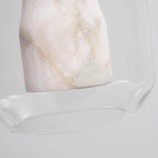 Close view of the unlit base of the alabaster column inside the glass shell of this Clérachic pendant, showing its pale veining and rough stone patch.