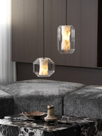Two Clérachic pendants, one wide and one tall, hang above a marble table and grey seating in front of dark wood panelling.