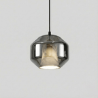 A wide Clérachic pendant with a smoke grey glass shell on a black cord, showing the pale alabaster inside, on a plain light grey backdrop.