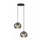 Two wide smoke grey glass Clérachic pendants hang at different heights from a round black canopy on a pale backdrop.