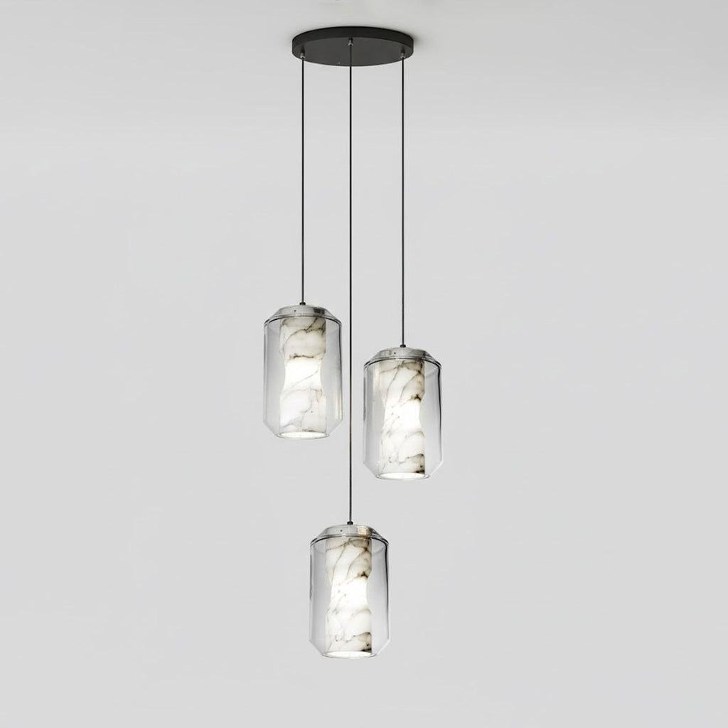 Three tall clear glass Clérachic pendants with veined alabaster hang at staggered heights from a round black canopy on pale grey.