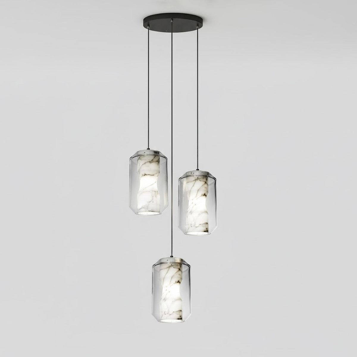 Three tall clear glass Clérachic pendants with veined alabaster hang at staggered heights from a round black canopy on pale grey.