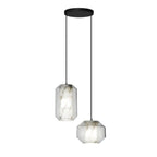 One tall and one wide Clérachic pendant with clear glass and white alabaster hang from a round black canopy on a white backdrop.