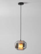 A wide Clérachic pendant on a black cord and canopy, its smoke grey glass shell showing a warm glow from the alabaster inside.