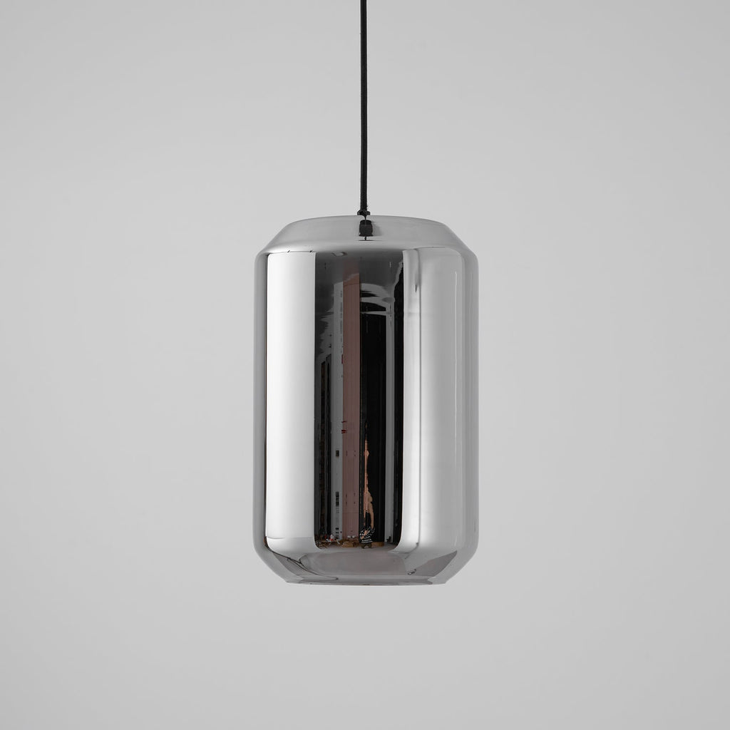 A tall, unlit Clérachic pendant with a mirrored smoke grey glass shell on a black cord, against a light grey backdrop.