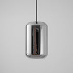 A tall, unlit Clérachic pendant with a mirrored smoke grey glass shell on a black cord, against a light grey backdrop.