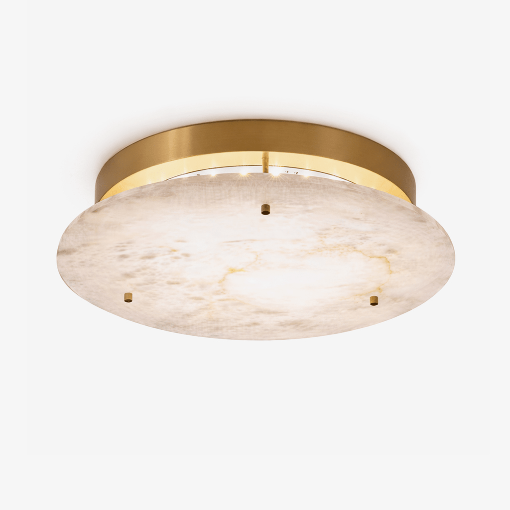 Clérachic alabaster disc ceiling light with a brass canopy and three small brass studs, seen from below on a plain white backdrop.
