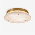 Clérachic alabaster disc ceiling light with a brass canopy and three small brass studs, seen from below on a plain white backdrop.