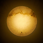 Lit Clérachic alabaster disc seen from below on a dark background, its glow warm gold and the veining showing through.
