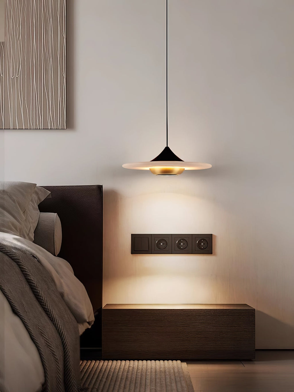 Clérachic Alabaster Disc Pendant Light over a dark oak nightstand, throwing a soft arc of light beside a leather bed.