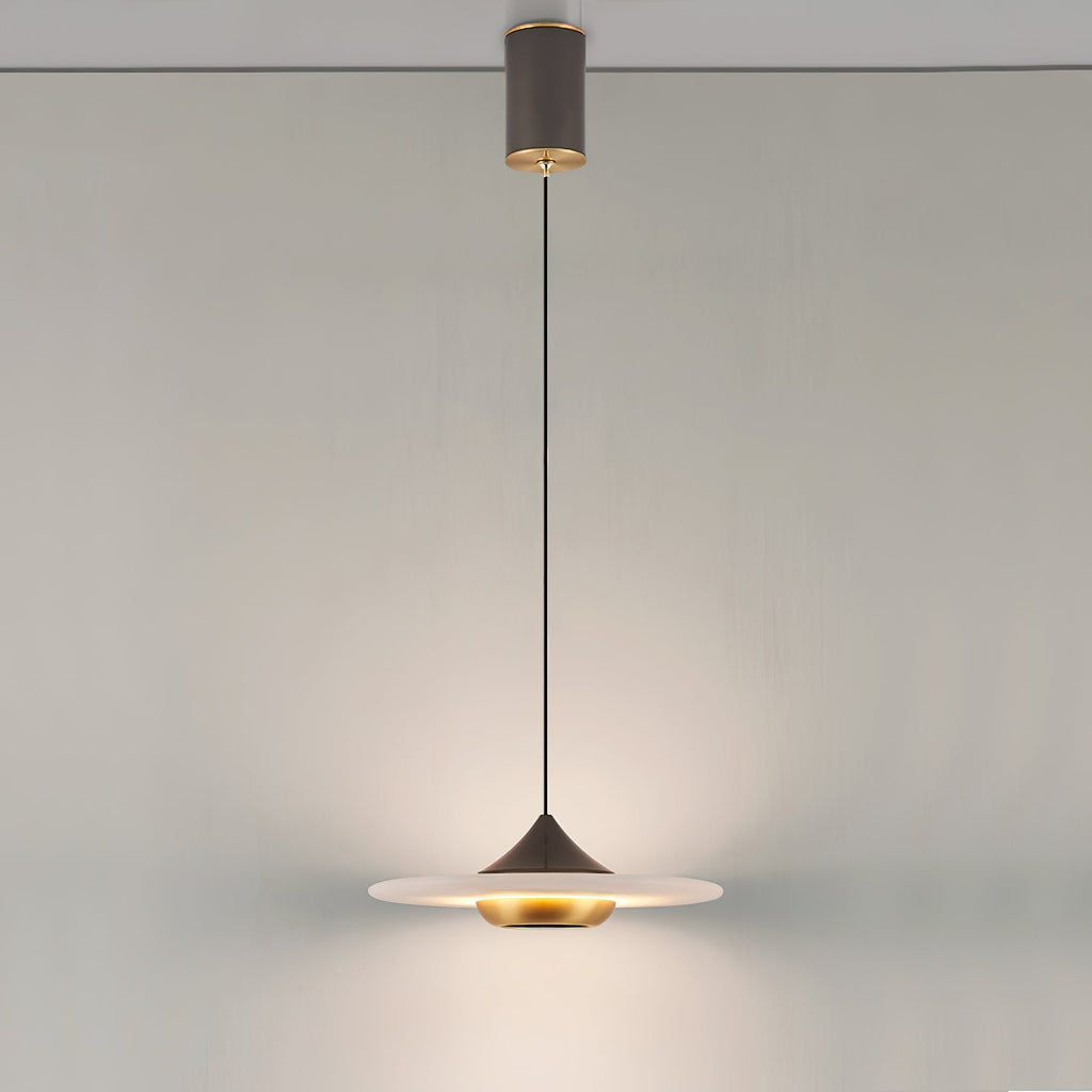 Clérachic Alabaster Disc Pendant Light hung from its cylindrical ceiling canopy, lighting a plain wall from a long drop.