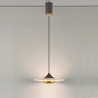 Clérachic Alabaster Disc Pendant Light hung from its cylindrical ceiling canopy, lighting a plain wall from a long drop.