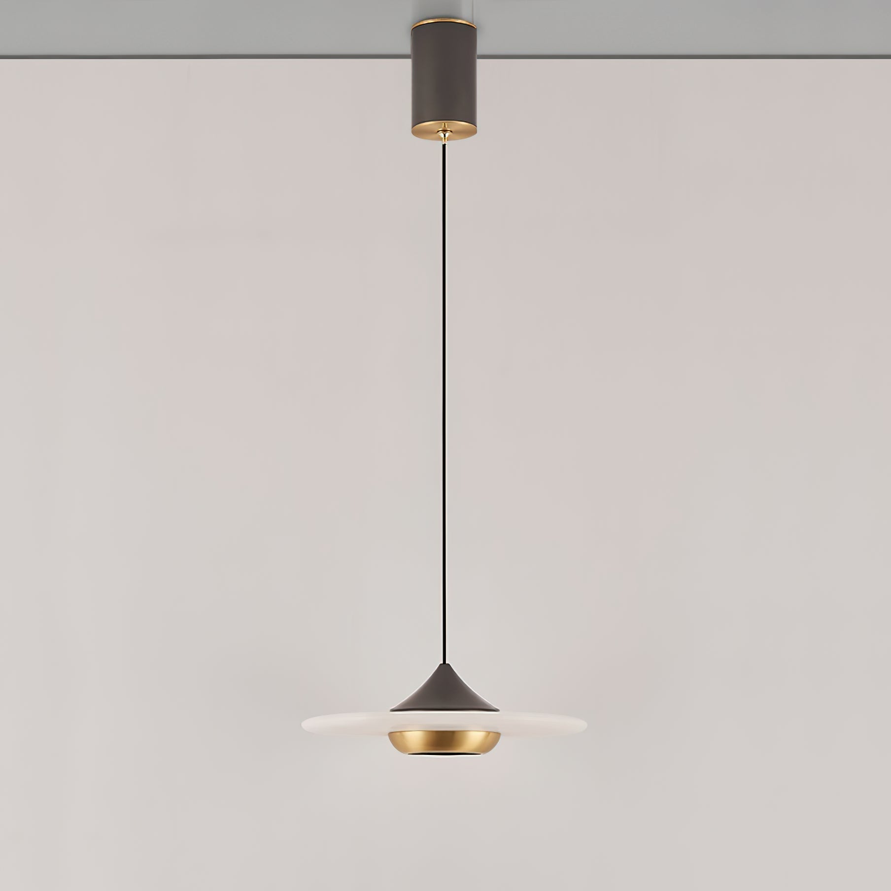 The unlit Clérachic Alabaster Disc Pendant Light in profile, dark cone cap sitting over the wide alabaster disc.
