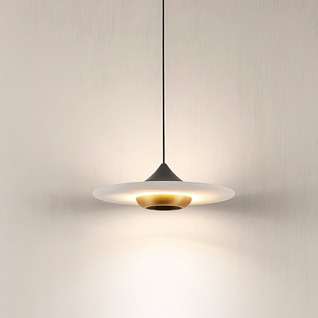 Close view of the Clérachic Alabaster Disc Pendant Light lit, warm light washing out from under the stone onto the wall.