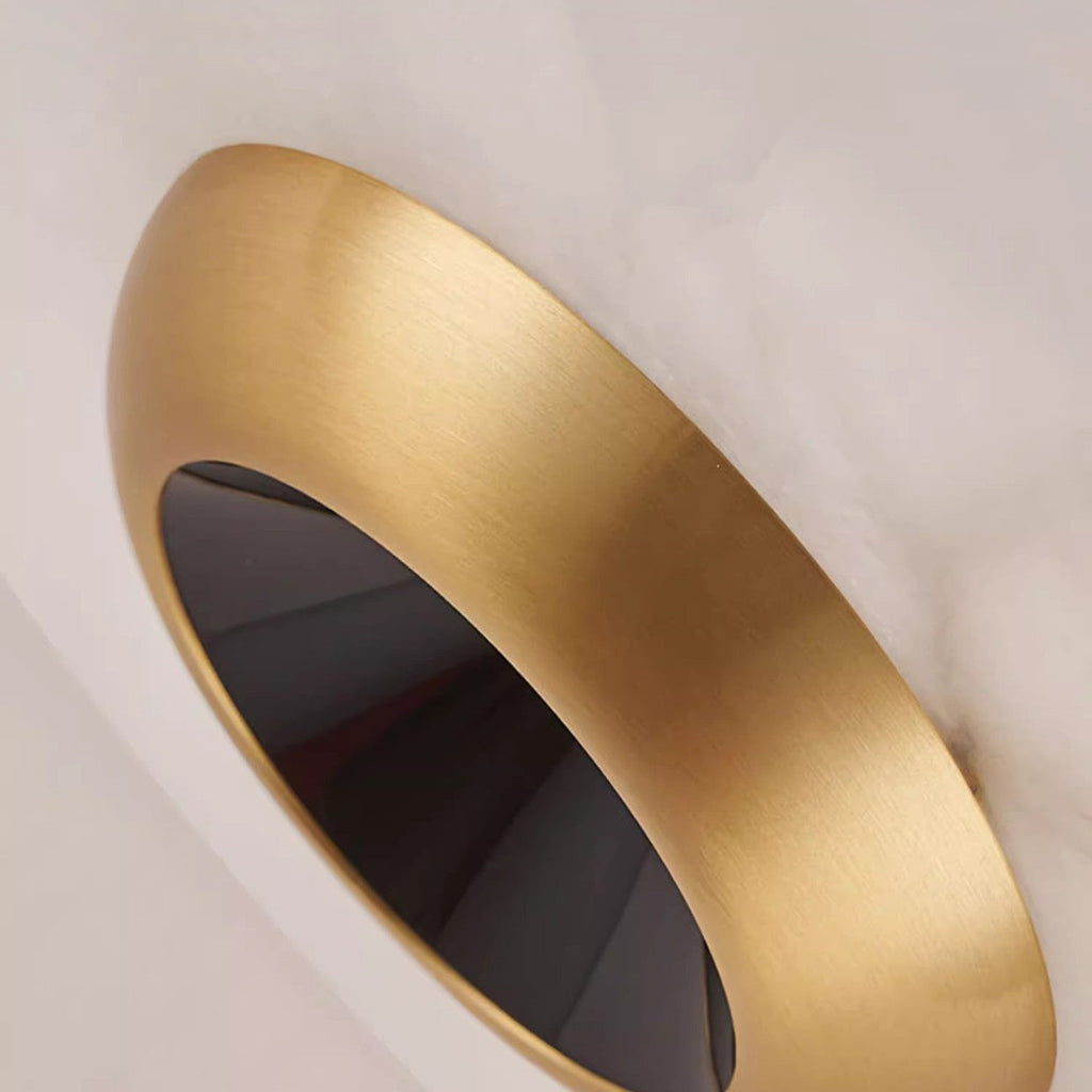 Macro of the brushed brass bowl on the Clérachic Alabaster Disc Pendant Light, its dark reflector visible inside the rim.