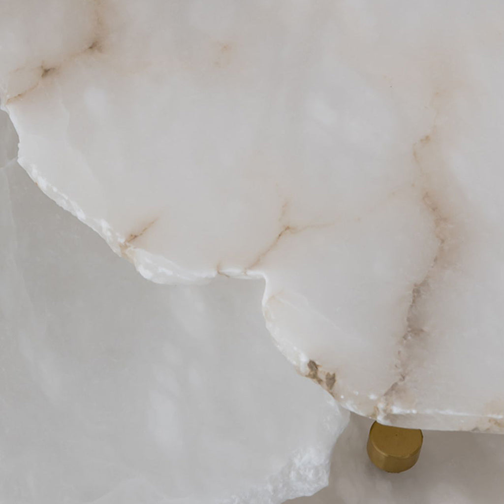 The natural stone of the Clérachic Alabaster Disc Pendant Light close up, raw quarried edge and honey-toned veining.