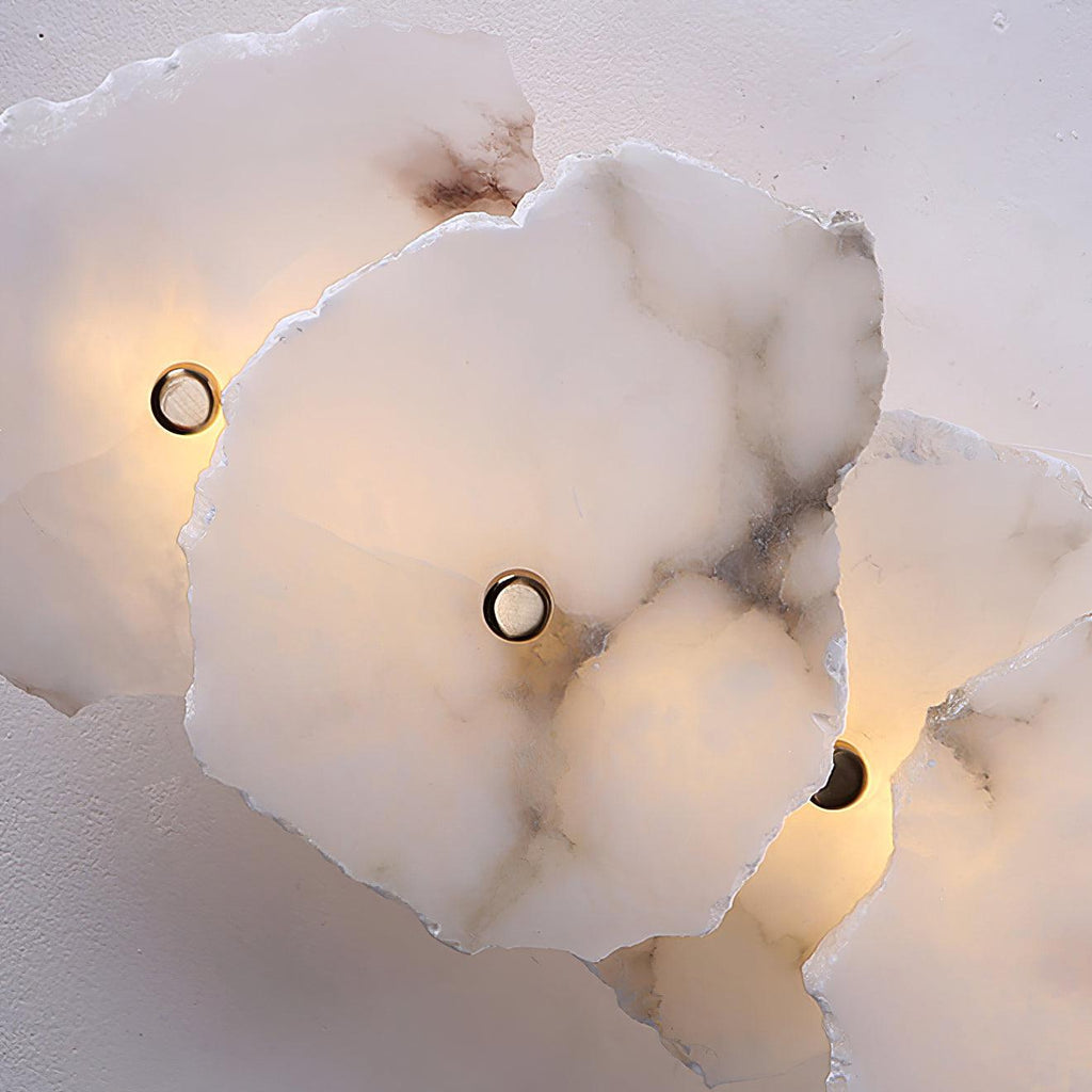 Clérachic's alabaster shades shown close-up from above, with three lit sockets set into the richly veined stone.