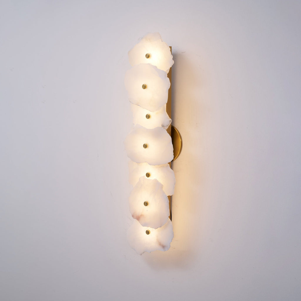 The Clérachic six-head alabaster lamp lit more brightly, its stone shades glowing warm along the wall.