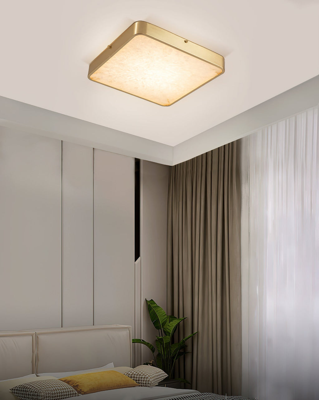 Square Clérachic alabaster flush ceiling light lit in a bedroom corner, tight to the ceiling beside long curtains and a plant.
