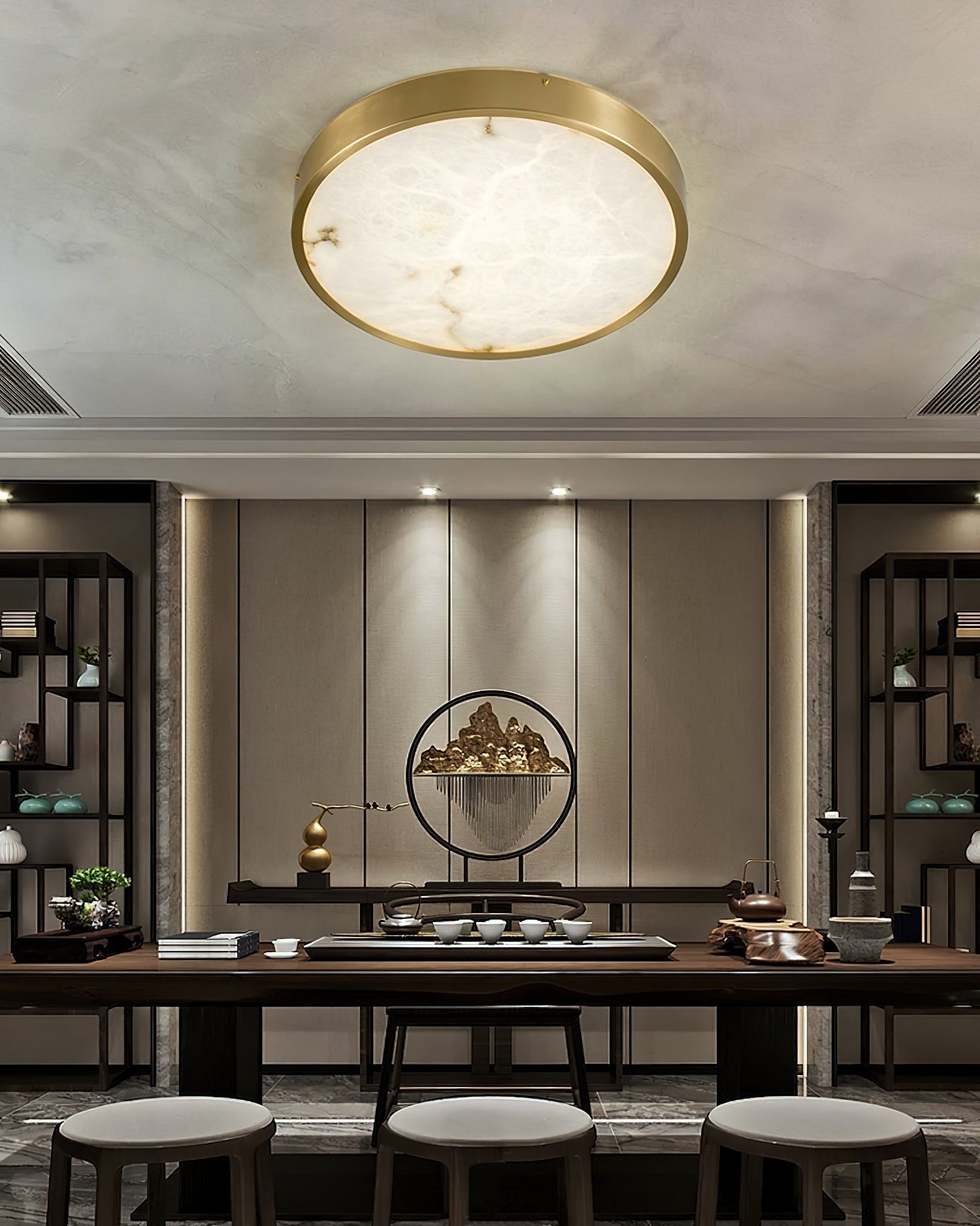 Round Clérachic alabaster flush ceiling light in a tea room, centred on the ceiling above a long dark table and stools.