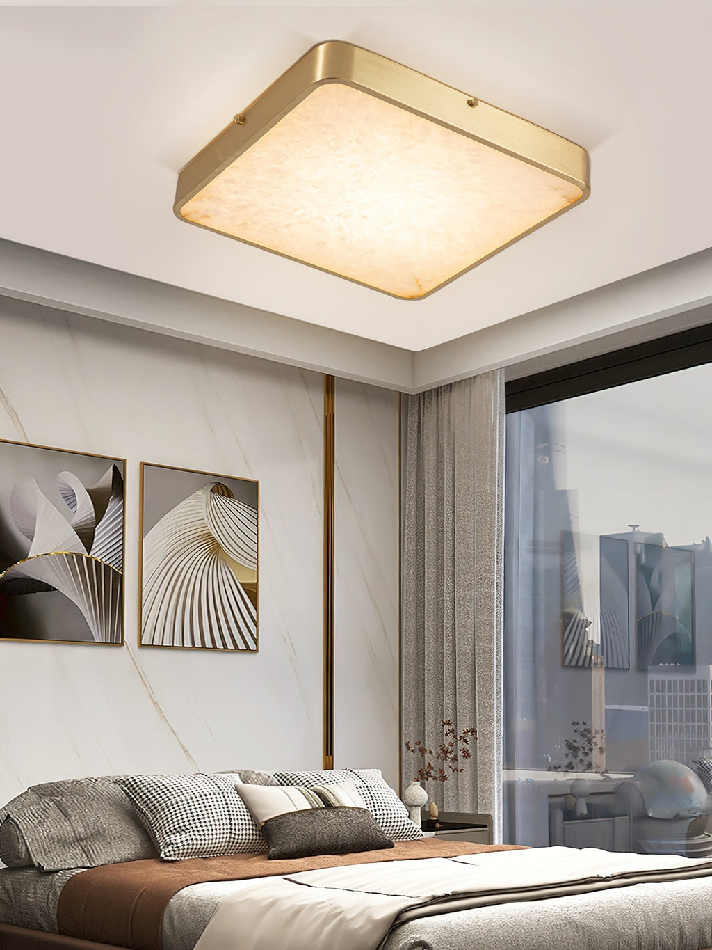 Square Clérachic alabaster flush ceiling light lit in a bedroom, between two abstract prints and a city window.