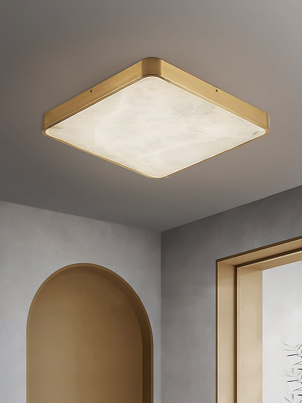 Clérachic alabaster flush ceiling light in square form on a grey ceiling, above an arched niche and a brass door frame.