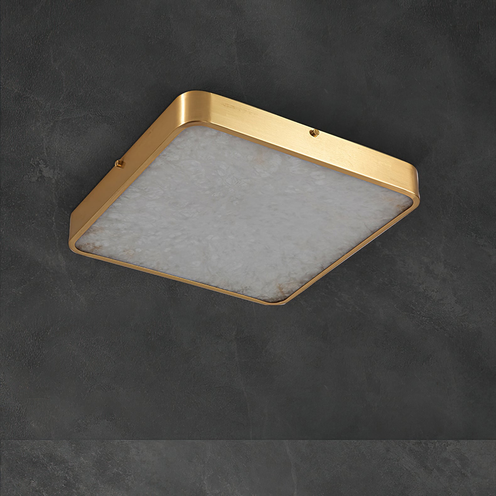 Unlit square Clérachic alabaster flush ceiling light on dark concrete, the stone face pale and the brass band matte.