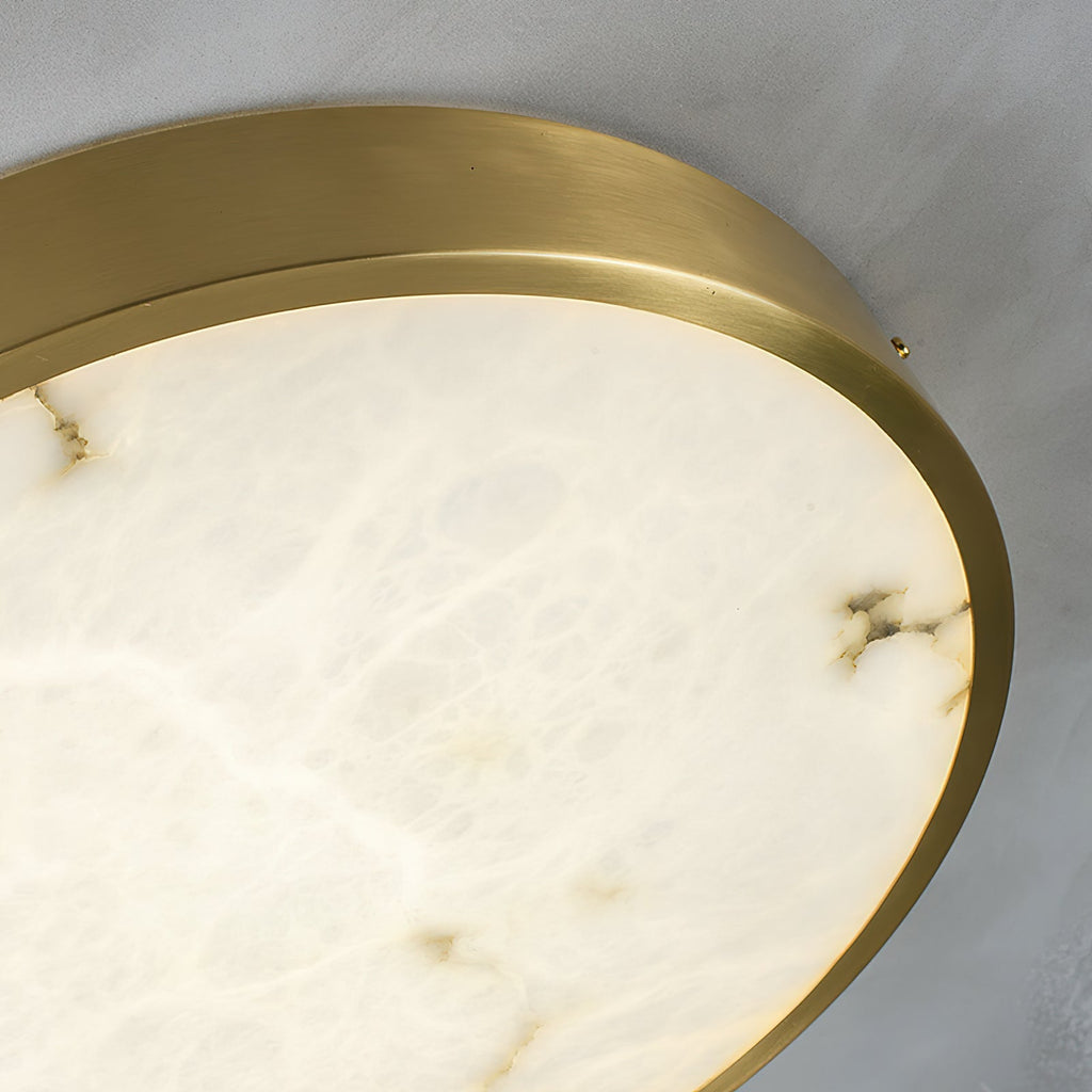 Close crop of the round Clérachic alabaster flush ceiling light, showing the brass band edge and the stone's soft veining.