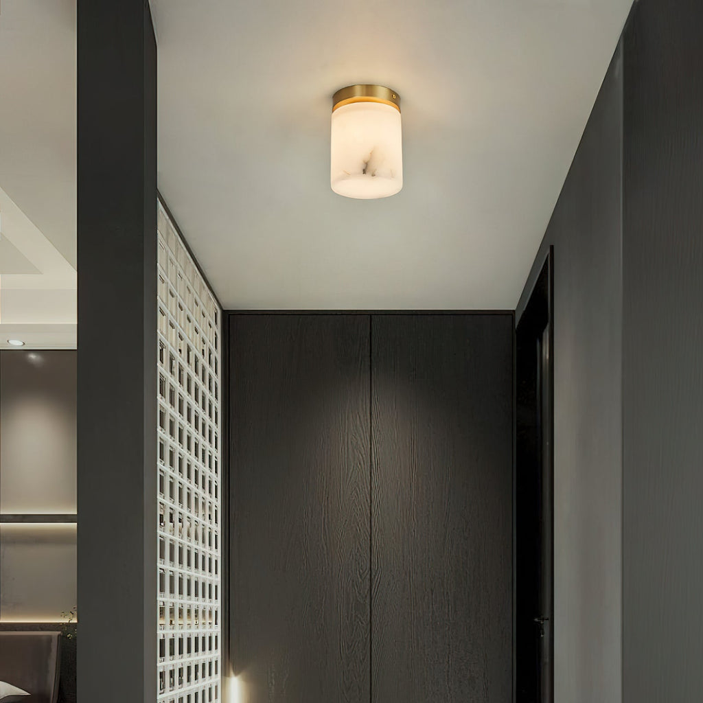 A single Clérachic alabaster cylinder ceiling light lighting a passage beside dark wood wardrobes and a white lattice screen
