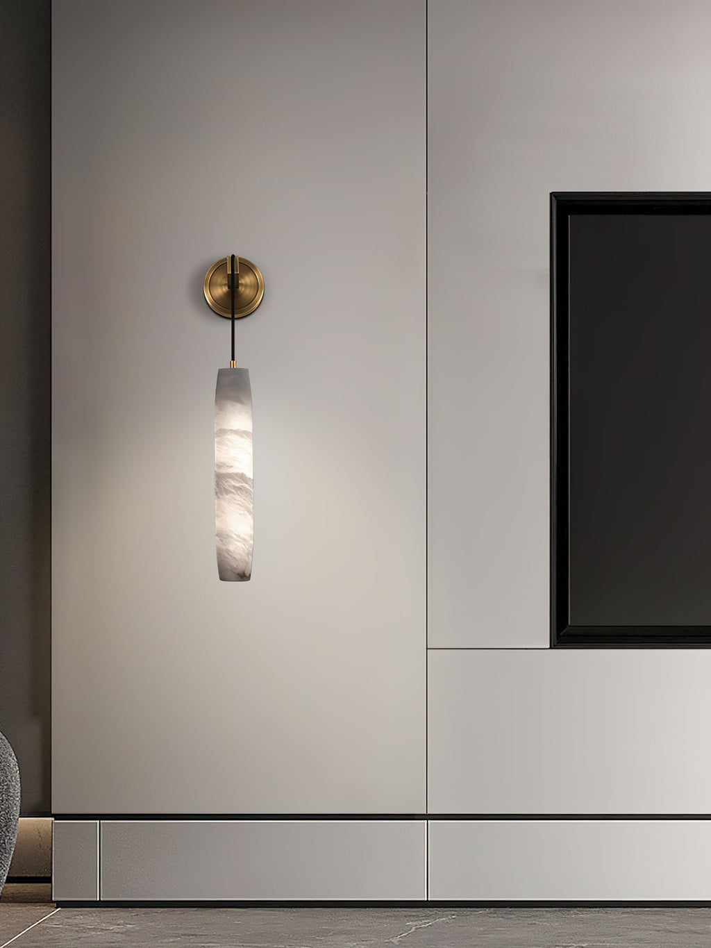 Clérachic sconce mounted on pale joinery, its unlit alabaster reading as carved stone beside a black niche.