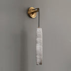 The Clérachic alabaster shade unlit on a warm grey wall, showing its milky veining and hand-finished edges.