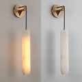 Clérachic sconce shown lit and unlit side by side, so you can see the alabaster shift from amber to pale stone.