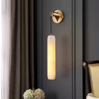 Clérachic sconce against dark grey panelling, framed by a linen curtain and a vase of white hydrangeas.