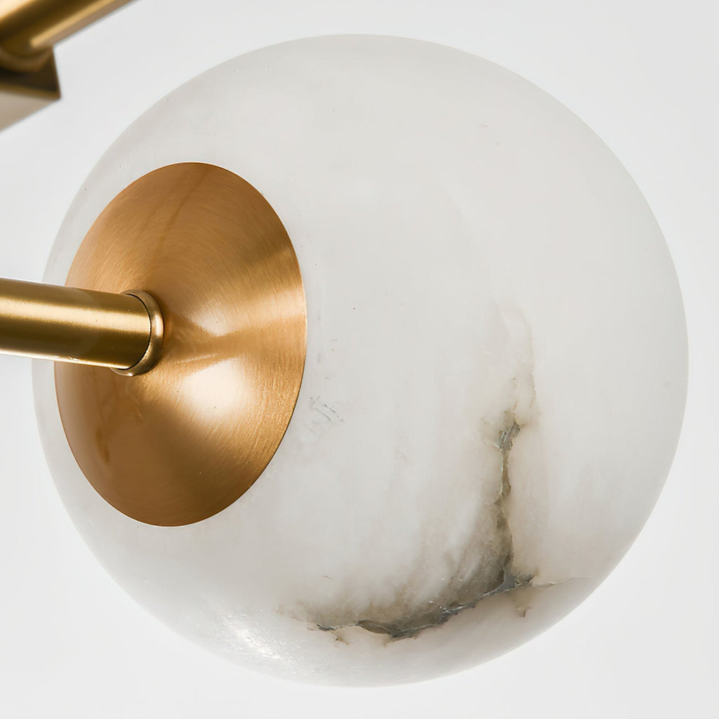 Single alabaster globe on the Clérachic Alabaster Globe Chandelier, its grey veining and brass collar shown up close.