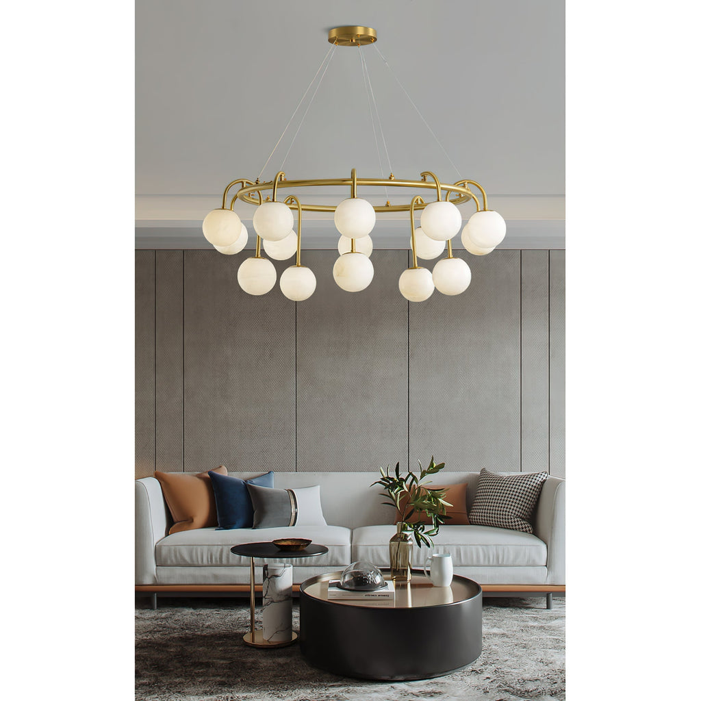Clérachic Alabaster Globe Chandelier lit above a pale sofa and round black coffee table in a grey panelled living room.
