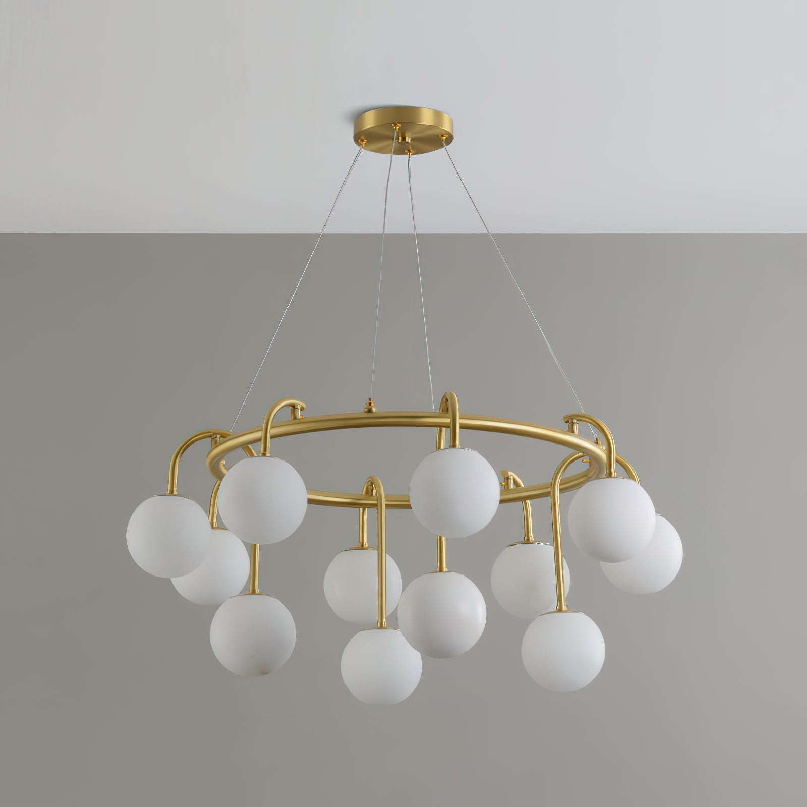 The Clérachic Alabaster Globe Chandelier seen head-on with its full cable drop, globes staggered around the brushed brass ring.