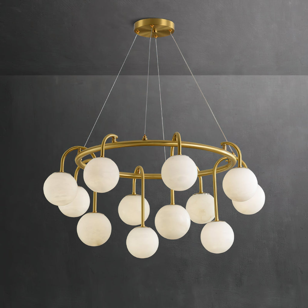 Clérachic Alabaster Globe Chandelier against a dark charcoal wall, where the honey veining through each stone globe reads clearly.