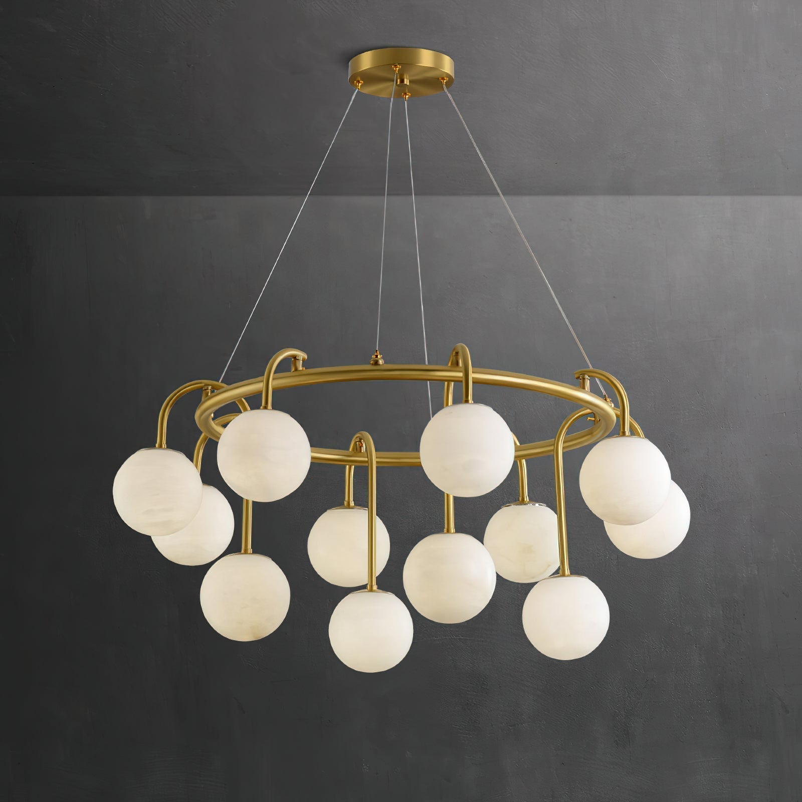 Clérachic Alabaster Globe Chandelier against a dark charcoal wall, where the honey veining through each stone globe reads clearly.