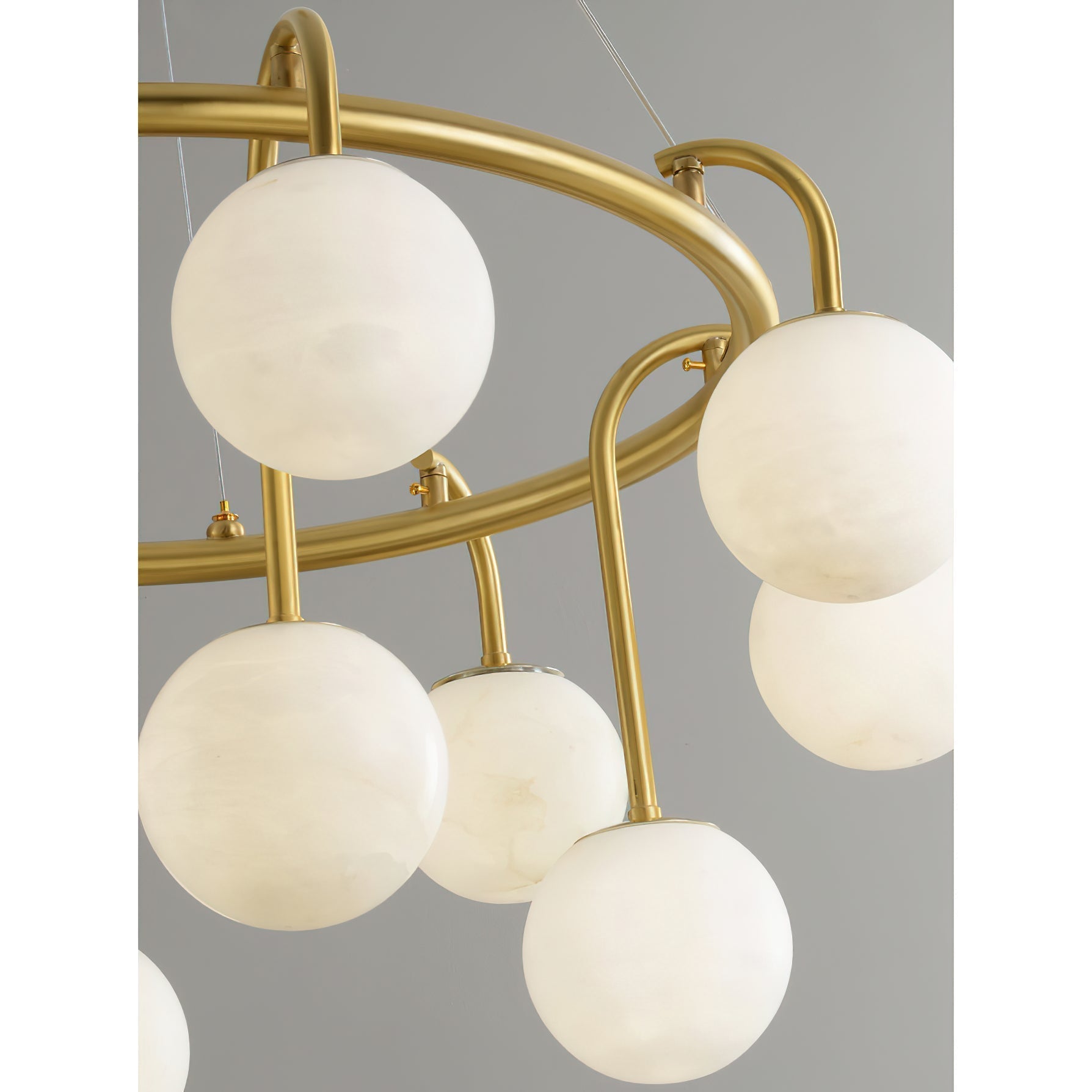 Detail of the Clérachic Alabaster Globe Chandelier ring, with hooked brass arms and short stems setting the globes at two heights.