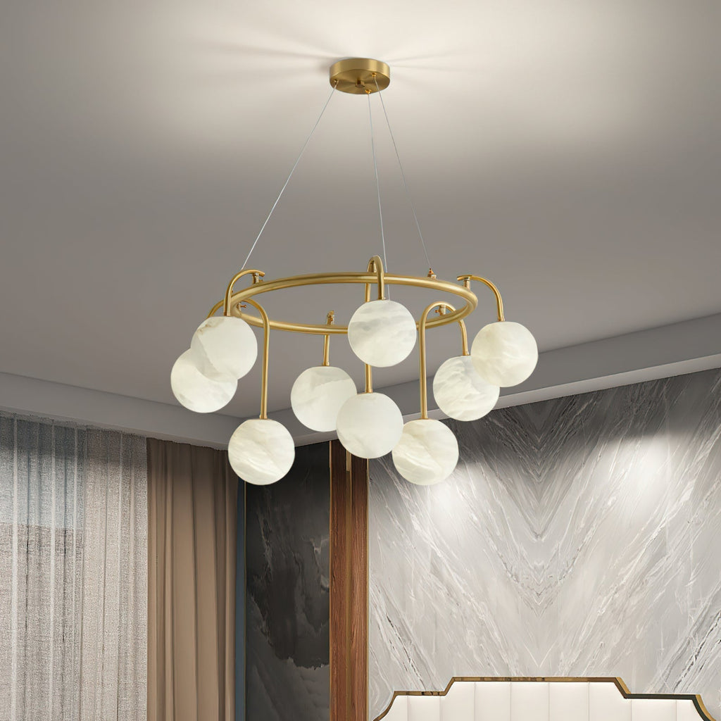 Clérachic Alabaster Globe Chandelier lit in a bedroom corner, its stone globes glowing beside a veined marble feature wall.