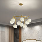Clérachic Alabaster Globe Chandelier lit in a bedroom corner, its stone globes glowing beside a veined marble feature wall.